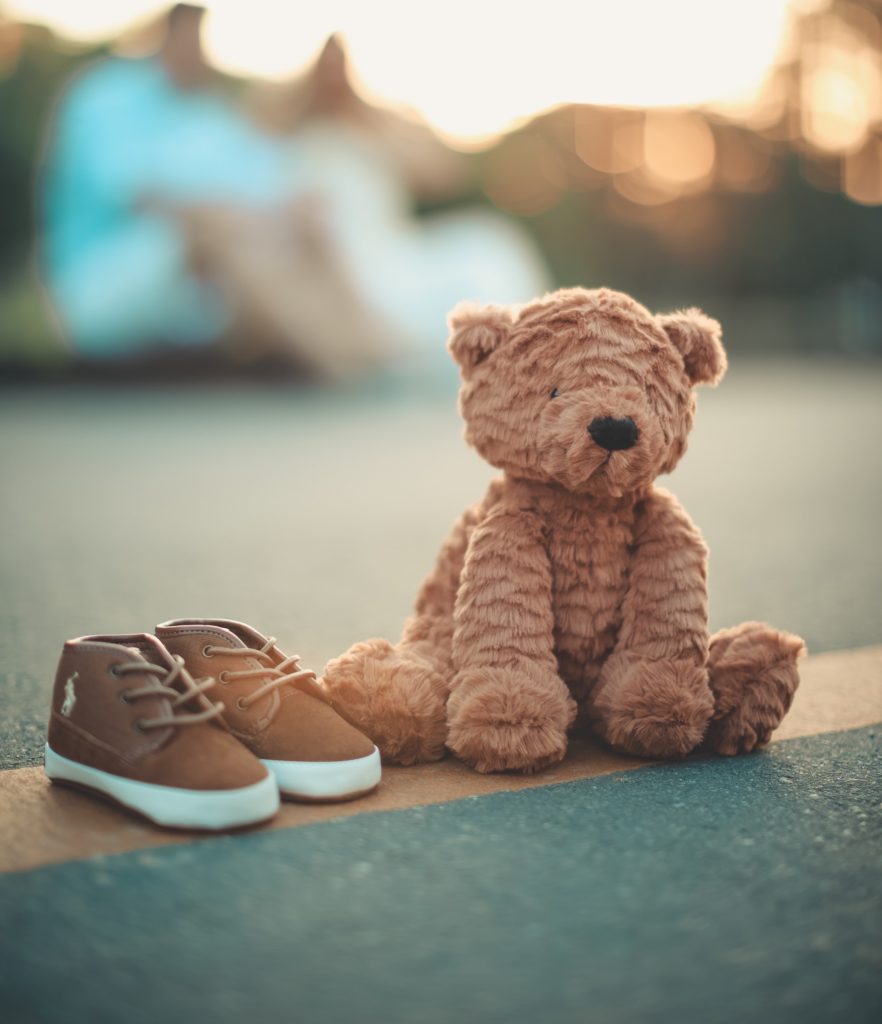 Mise en scène d'une paire de chaussures à coté d'un ours en peluche